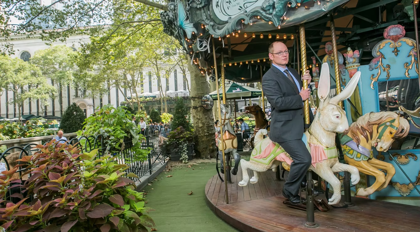 Louis Hyman standing on a carousel in a park